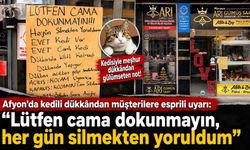 Afyon’da cam silmekten yorulan esnafın eşi, vitrindeki notuyla güldürdü